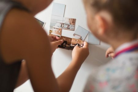 a little girl holding up a picture of a house